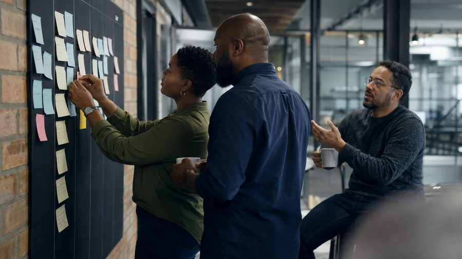 Middle managers prioritising work at a kanban wall